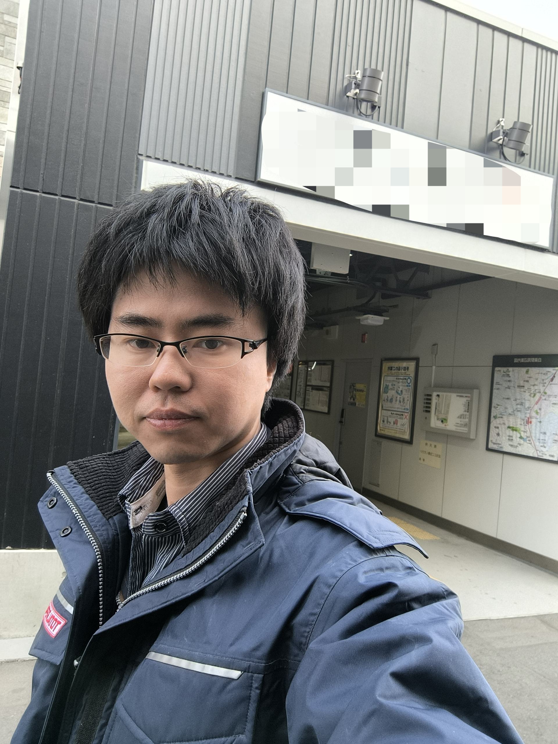 建物の前でカメラを見つめるトータルリペア澄の李陽さん