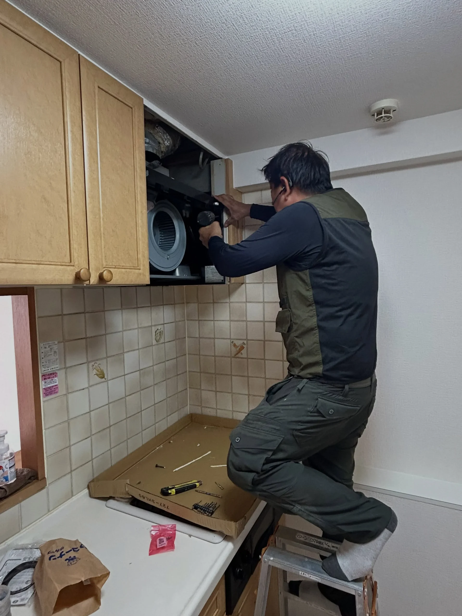 住宅のキッチンで設備工事を行う河野さん
