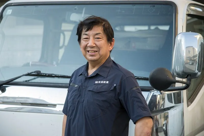 作業車の前で笑顔を見せる世良淳志社長